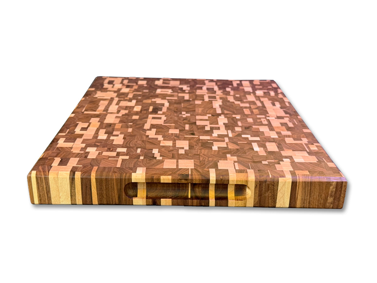 Angled view of a maple and walnut chaotic cutting board with a recessed side handle